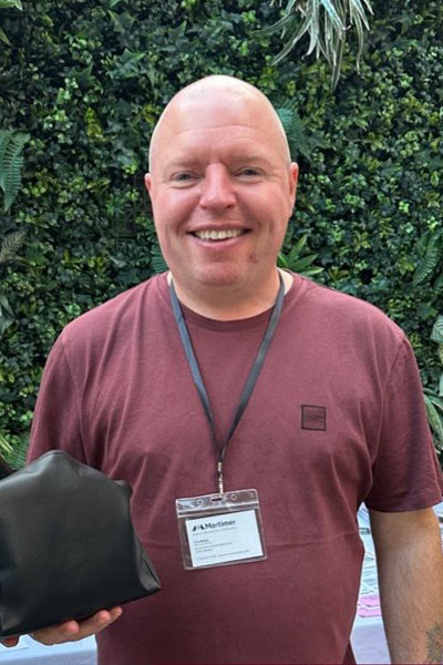 Tim showing off his raffle prize at the July 2025 RSVIP Networking Event